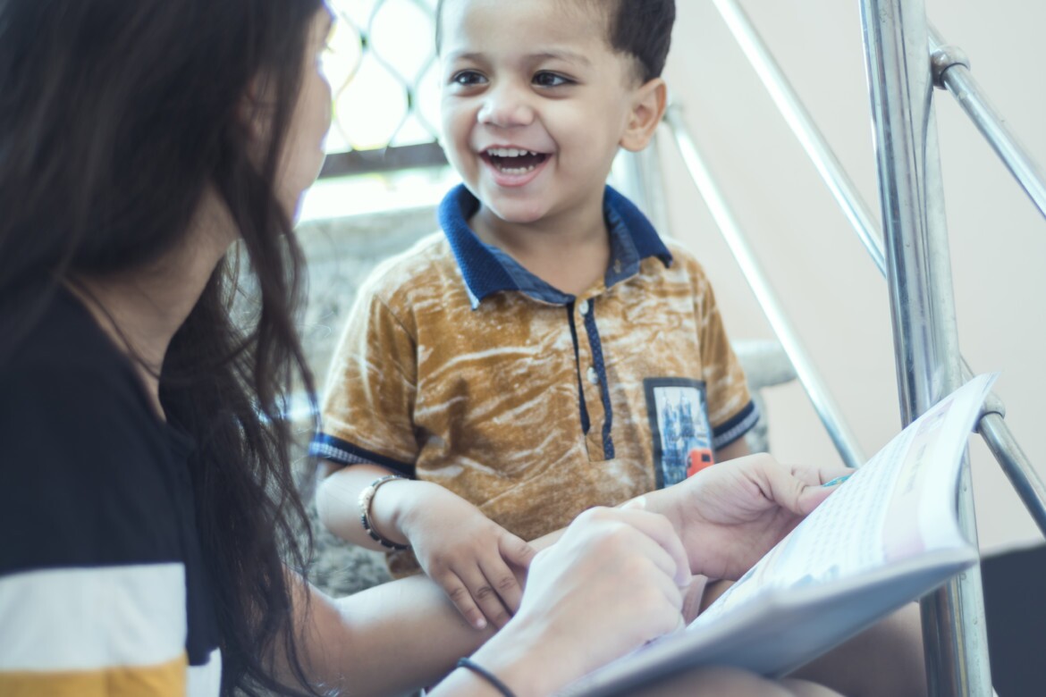 Boy smiling looking at teacher.