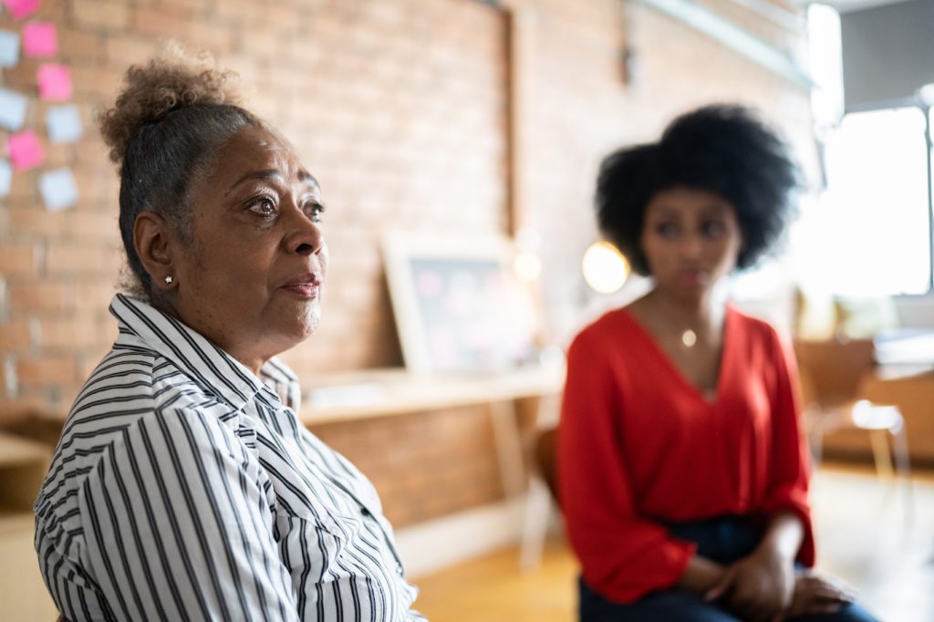 Senior woman talking to a younger coworker