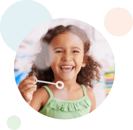 young girl laughing while making bubbles